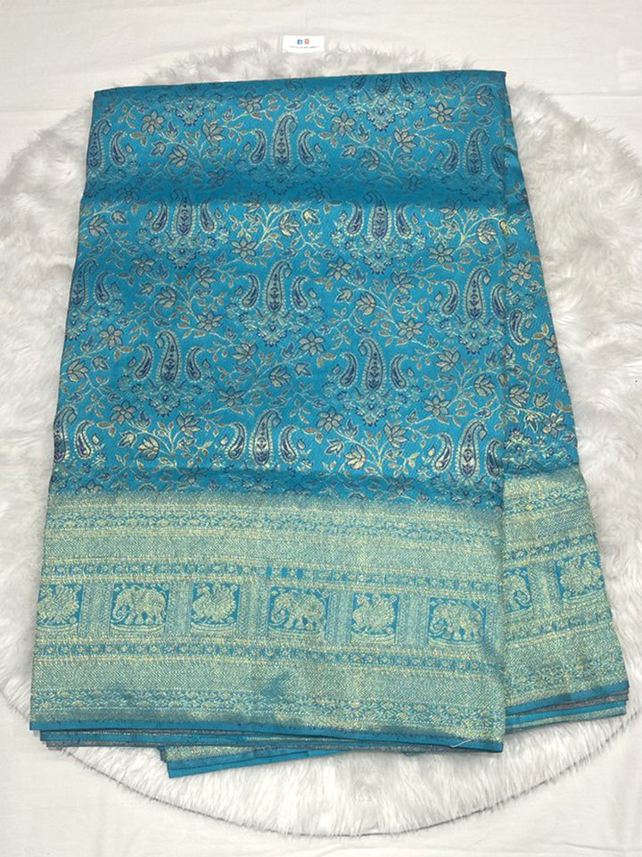 Vibrant Aqua Blue Kanjivaram Pattu Saree with all-over Paithani-style Paisley and Floral motifs woven in silver and gold Zari, featuring a Tone-on-Tone border with traditional Elephant figures.