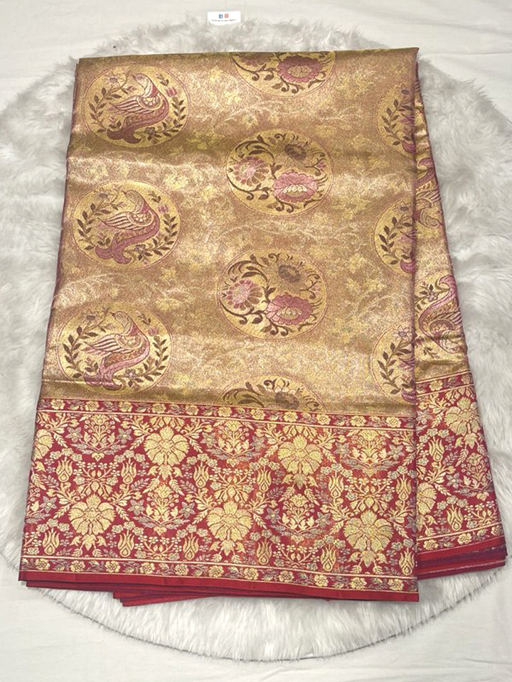 Opulent Gold Kanjivaram Pattu Saree featuring large, circular woven Chakra and peacock motifs in pink and gold Zari, set against an extra-wide, dense Contrast Red Zari Brocade border.