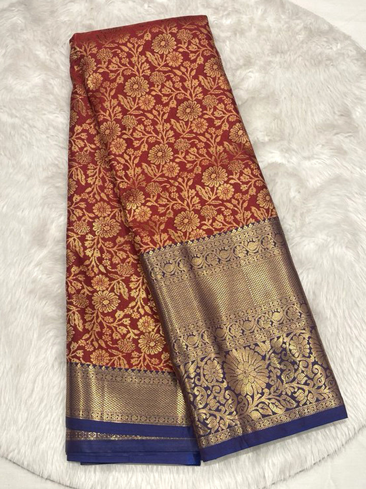 Traditional Deep Red Pattu Saree with all-over Gold Zari floral brocade, featuring a broad Contrast Navy Blue Zari Brocade border.