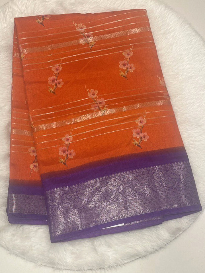 Orange soft silk saree with floral prints, horizontal zari stripes, and contrast purple paisley zari border.