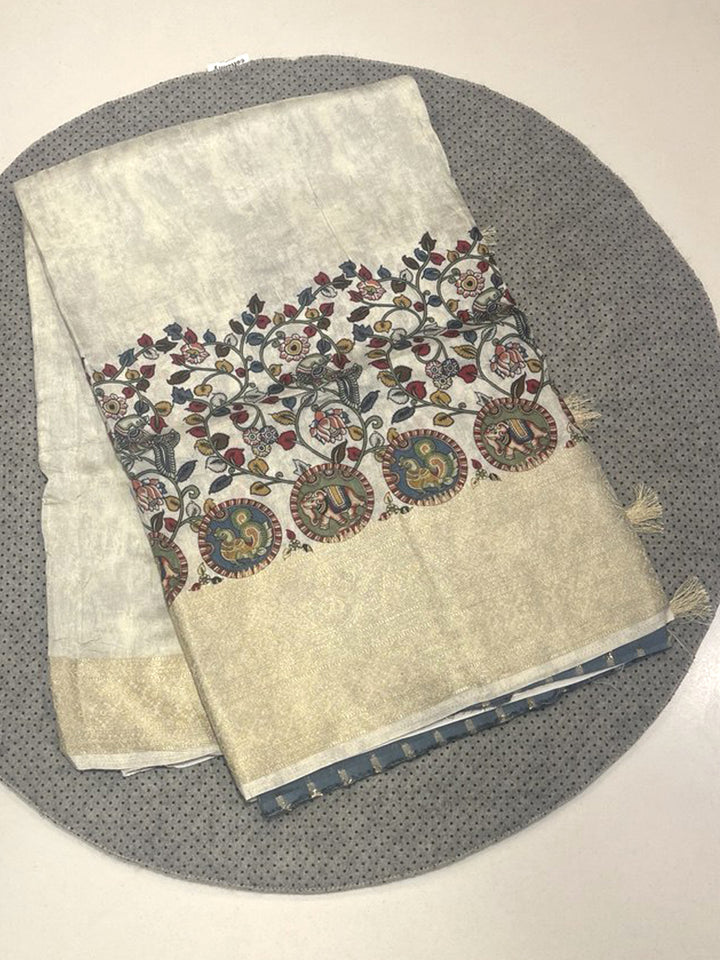 Cream Pashmina silk saree featuring Pen Kalamkari print of peacocks and elephants with a self gold Kanchi Zari border and tassels.